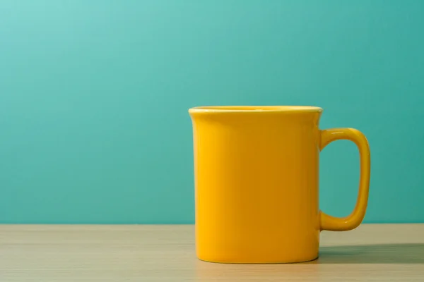 yellow mug on wooden table