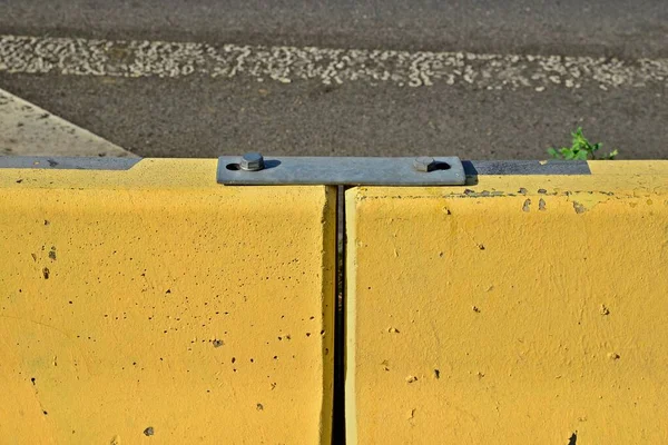 Δύο Κίτρινα Τσιμεντένια Τουβλάκια Συνδεδεμένα Χαλύβδινο Σύνδεσμο Jersey Φράγμα Τοίχος — Φωτογραφία Αρχείου