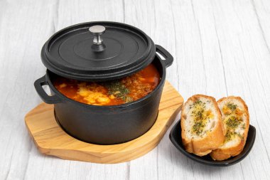 Yanında sarımsaklı ekmek olan domates çorbası.