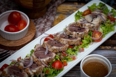 Tavada kurutulmuş ton balığı salatası ve vişneli domates.