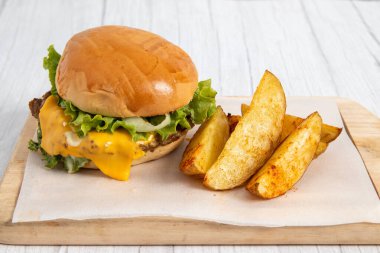 Tahtada peynirli ve patatesli hamburger.