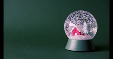 Kar bir Noel kristal küresinin içine düşüyor. Noel konsepti 4K video.
