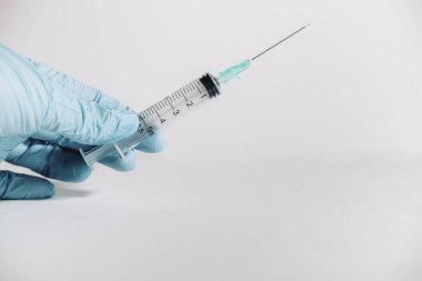 Eldivenli elinde beyaz arka planda kas içi iğneyle şırınga tutuyor. Tıbbi konsept. Boşluğu kopyala