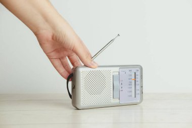 Beyaz arka planda eski bir radyoda bir el. Radyo konsepti. Klasik stil.