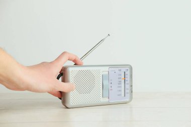 Beyaz arka planda eski bir radyoda bir el. Radyo konsepti. Klasik stil.
