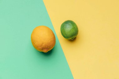 Yeşil ve sarı arka planda paralel bir limon ve limon. Meyve konsepti. Soyut kavram. Vejetaryen konsepti.