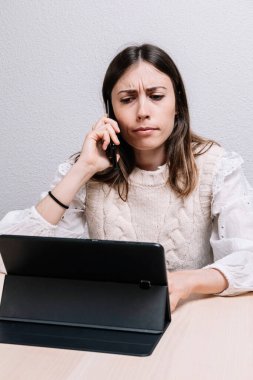 Telefonda konuşurken sinirli görünen bir kadın. Girişimci konsepti. Evde çalış. İfadeler.