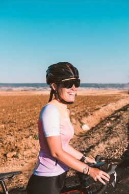 Gülümseyen genç bir kadın bisikletçinin portresi. Bisiklet konsepti. Spor konsepti.