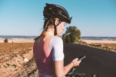 Genç bisikletçi kadın cep telefonuyla konuşuyor. Bisiklet konsepti. Spor konsepti.