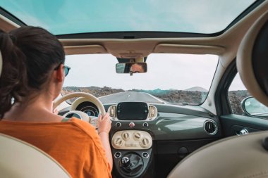 Yoldan aşağı araba süren beyaz bir kadın. Seyahat kavramı.