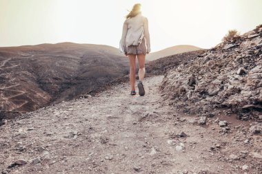 Gün batımında yolda yürüyen bir kadın. Yansıma konsepti. Yalnızlık kavramı