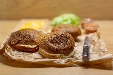 Masada hamburger ekmeği, marul ve peynir var. Ev yapımı hamburgerler..