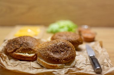 Masada hamburger ekmeği, marul ve peynir var. Ev yapımı hamburgerler..