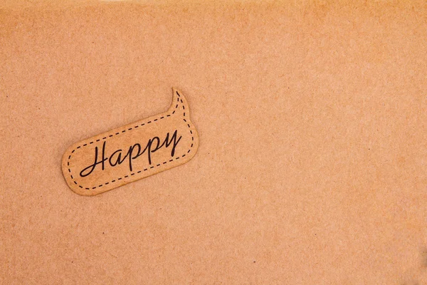 Happy tag on brown paper background — Stock Photo, Image