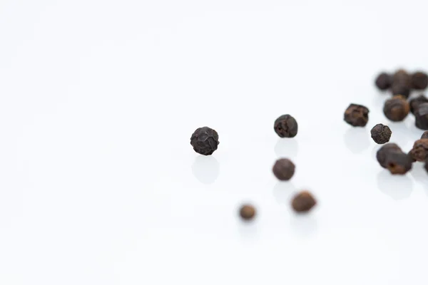 Primer plano seco pimienta negra sobre fondo blanco —  Fotos de Stock