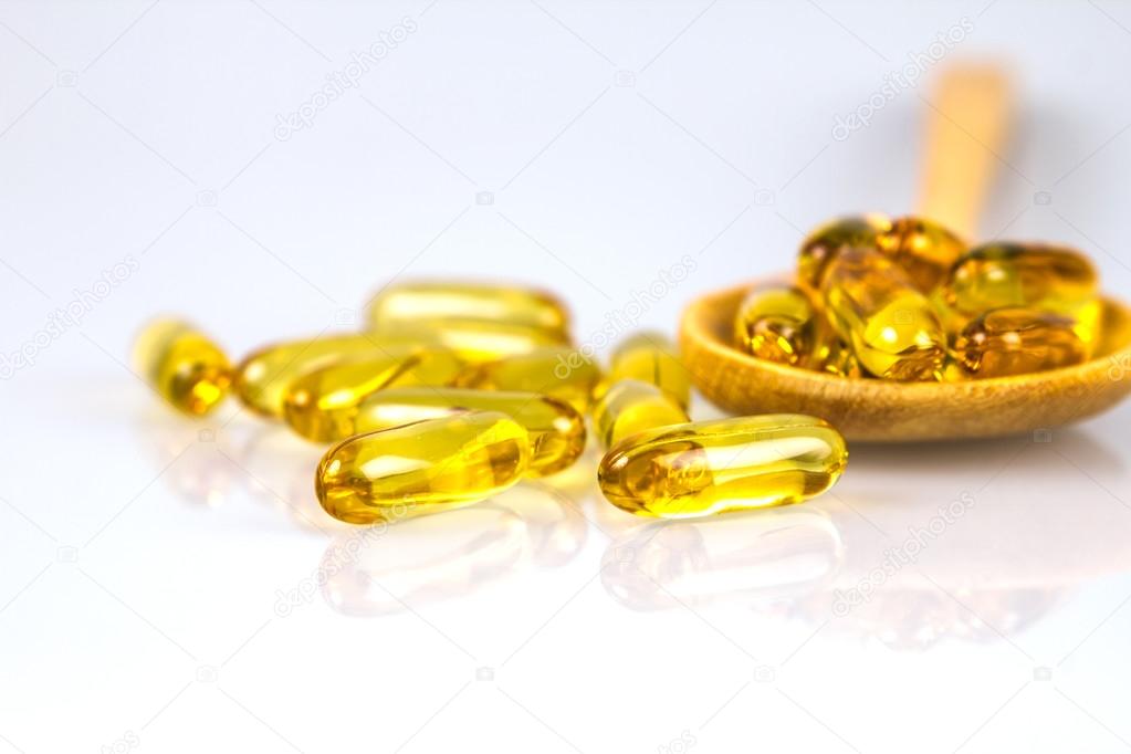 Closeup yellow soft gelatin supplement fish oil capsule 