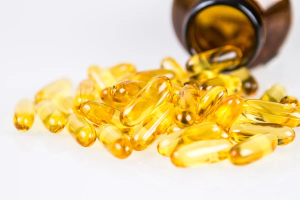 Closeup yellow soft gelatin supplement fish oil capsule — Stock Photo, Image