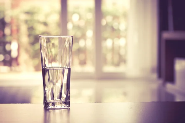 Крупним планом Склянка води на столі у вітальні, вінтажний і ретро стиль — стокове фото