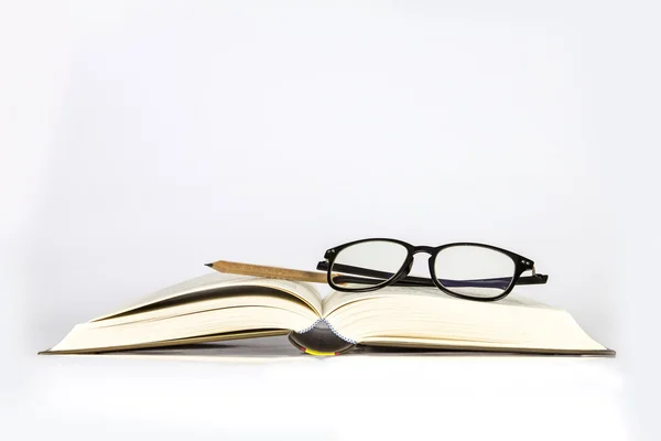 Black rimmed glasses placed on opened book — Stock Photo, Image