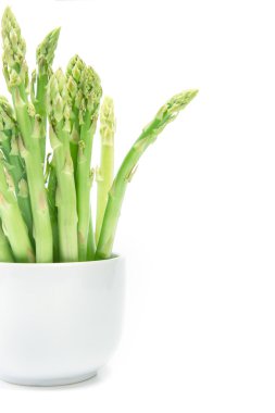 Beyaz arka plan üzerinde beyaz bir fincan kuşkonmaz düzenlemek