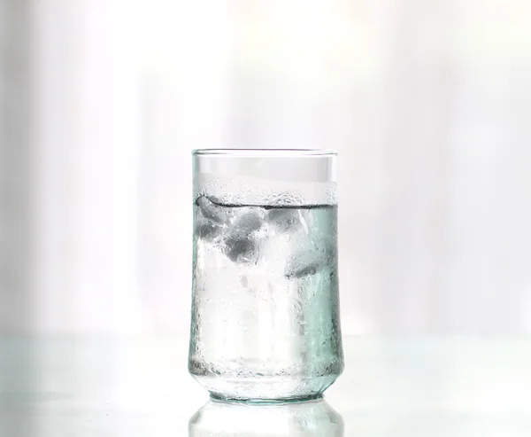 Bicchiere di bevanda fresca fresca fresca con cubetto di ghiaccio sul tavolo — Foto Stock
