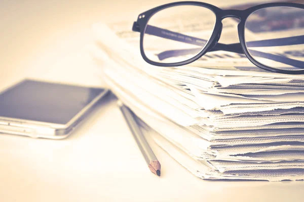 Reading eyeglasses with stacking of newspaper background , busin — Stock Photo, Image