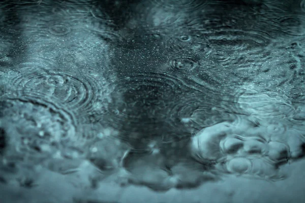 Sfondo sfocato astratto dal flusso di pioggia verso il basso sul pavimento nero — Foto Stock
