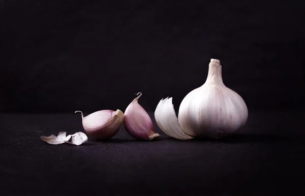 Un arreglo de naturaleza muerta de tres bulbos de ajo enteros agrupados en — Foto de Stock