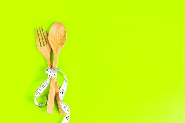 Tenedor de madera y cuchara atada con cinta métrica en verde vibrante — Foto de Stock