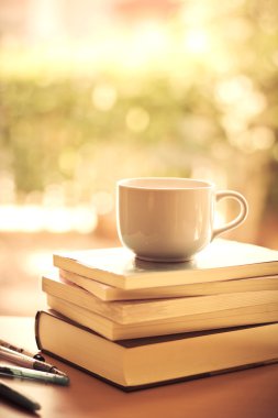 seçici odak beyaz kahve fincanı ve kitap ile swe istifleme