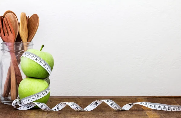 Manzana verde con cinta métrica sobre fondo de madera — Foto de Stock