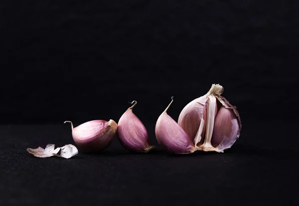 Un arreglo de naturaleza muerta de tres bulbos de ajo enteros agrupados en —  Fotos de Stock