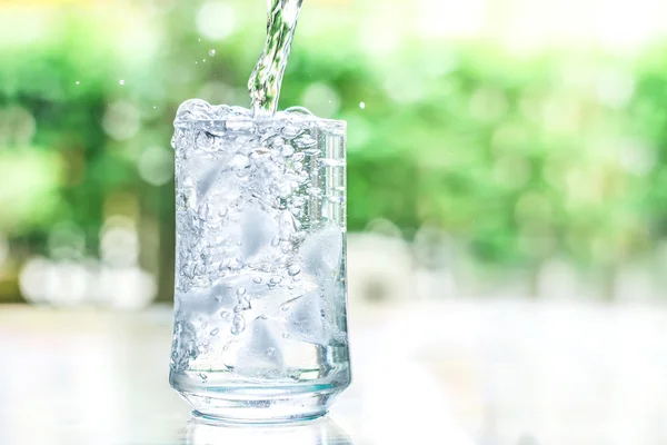 The glass of cool water with some water flow down motion — Stock Photo, Image