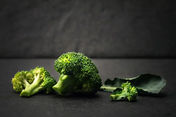 Naturaleza muerta con brócoli verde fresco en el plato de piedra negro —  Fotos de Stock