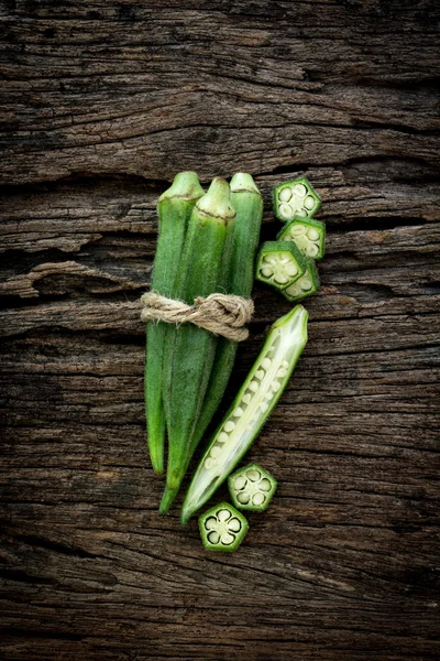Close up fresh okra on wooden plate , overhead shot — Stock Photo, Image