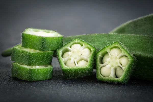 Close up the fresh okra on black stone background — Stock Photo, Image