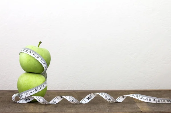 Green apple with Measuring tape on wooden background — Stock Photo, Image