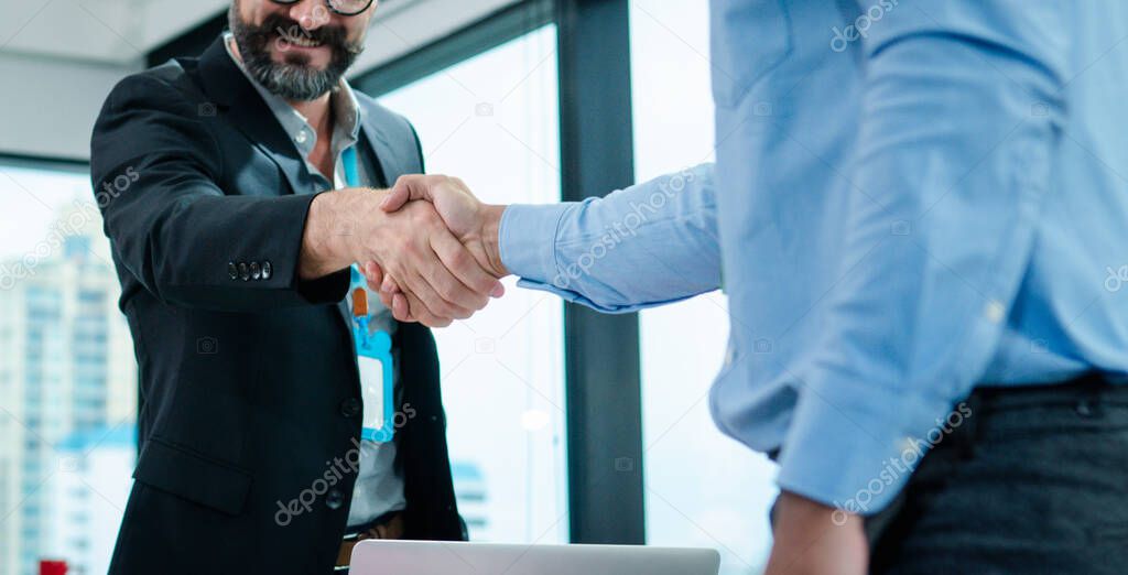 Businessperson is shaking hand with the client or his Employees after they finished the meeting. They have a good deal of the project.