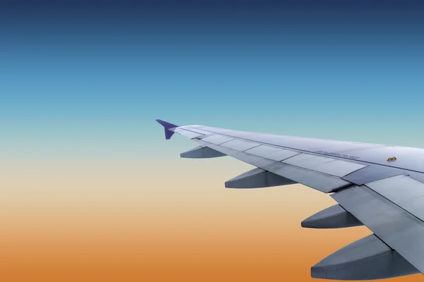 Wing of an airplane flying above the clouds — Stock Photo, Image