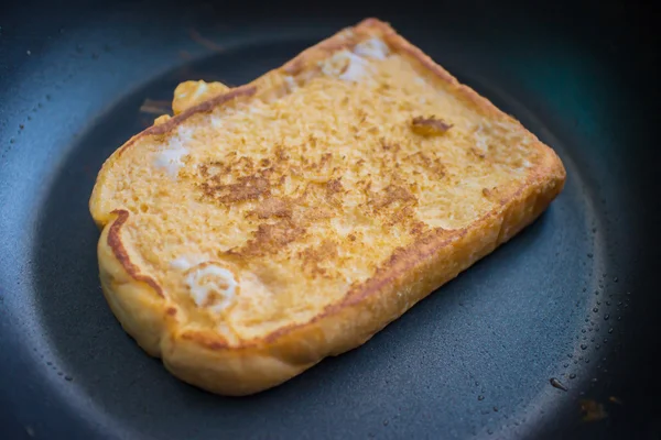 Cottura per un french toast su padella con profondità di campo — Foto Stock