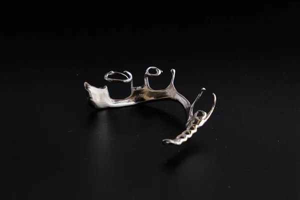 Siyah arkaplanda diş aletleri ve takma dişler var..