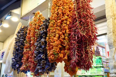 Markette sallanan renkli kurutulmuş sebzeler, canlı bir ürün çeşitliliği sunuyor..