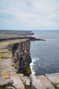 İrlanda 'nın dramatik kıyı kayalıkları bulutlu bir gökyüzünün altında okyanusa bakıyor..