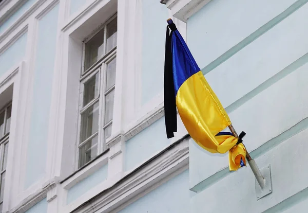 Ukrainian flag on a building with a black mourning ribbon