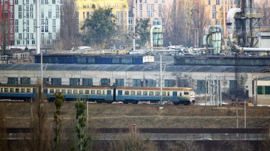 Tren şehrin etrafında uzun evlerin arka planına doğru gidiyor.