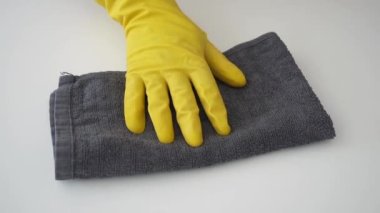 Temizlik ve dezenfeksiyon konsepti. Sarı lastik eldivenli el, Coronavirus COVID-19 'un yayılmasını önlemek için gri antibakteriyel dezenfektan peçeteyle masayı temizler. Moda Renkleri 2021