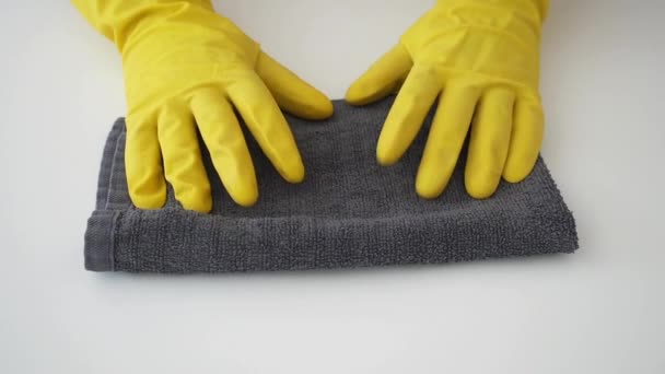 Conceito de limpeza e desinfecção. Mãos de close-up em luvas de borracha amarela batendo no toalhete desinfetante antibacteriano cinza para evitar a propagação do coronavírus COVID-19. Cores da moda 2021 — Vídeo de Stock