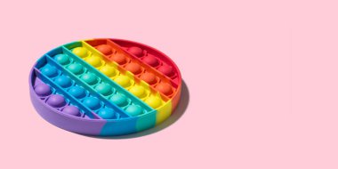Yuvarlak renkli Pop it toy. Pembe arka planda izole edilmiş yeni popüler silikon anistress oyuncağı. Minimalist bir bakış açısı. Boşluğu kopyala