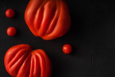 Siyah arka planda büyük, lezzetli, olgun, çirkin çiftlik domatesleri. Doğal sağlıklı sebze konsepti. Minimalist besin kompozisyonu düzdü