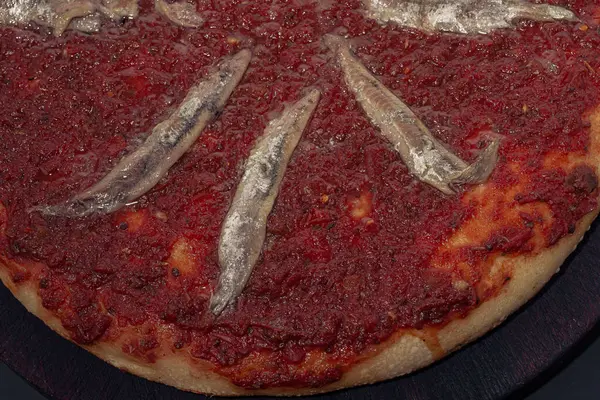 Zelfgemaakte ansjovis Italiaanse Pizza tomatensaus. Zwarte achtergrond. — Stockfoto